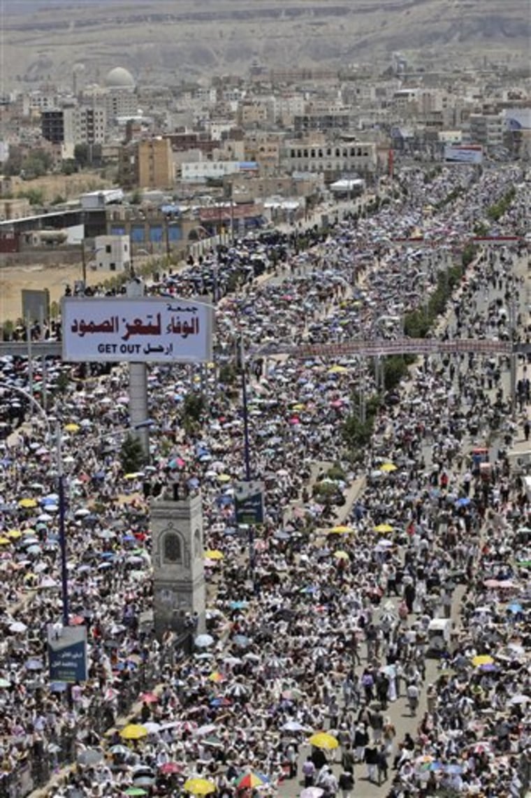 Anti-government protestors, attend a demonstration demanding the resignation of Yemeni President Ali Abdullah Saleh, in Sanaa, Yemen, Friday, June 3, 2011. A government official says Yemen's president was lightly injured and four top officials wounded when opposition tribesmen struck his palace with rockets. Billboard center reads in arabic, \" Loyal for Taiz\". (AP Photo/Hani Mohammed)